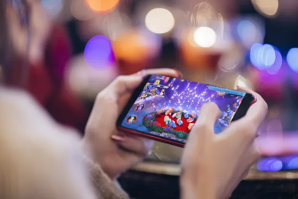 A young woman relaxing with her phone while dynamic casino elements float around her, illustrating the smooth mobile experience offered by the JLWAFA app.