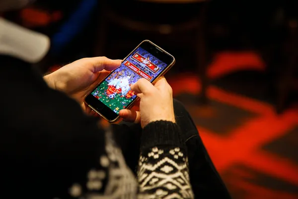 A man focused on his laptop with live stats in the background, highlighting the dedicated sports and gaming features of the JLWAFA mobile app.