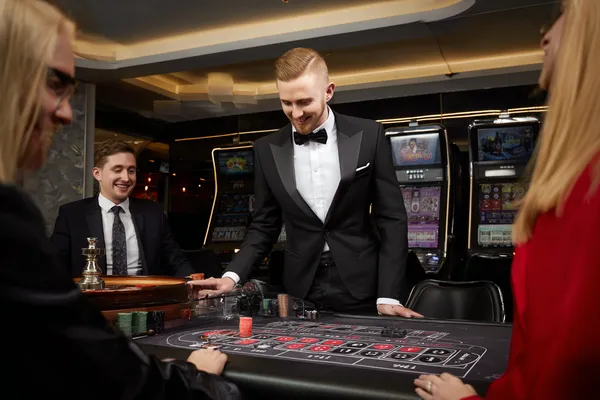 A stylish woman beside vibrant slot machines displaying glowing sevens, showcasing the variety of top slots at JLWAFA.